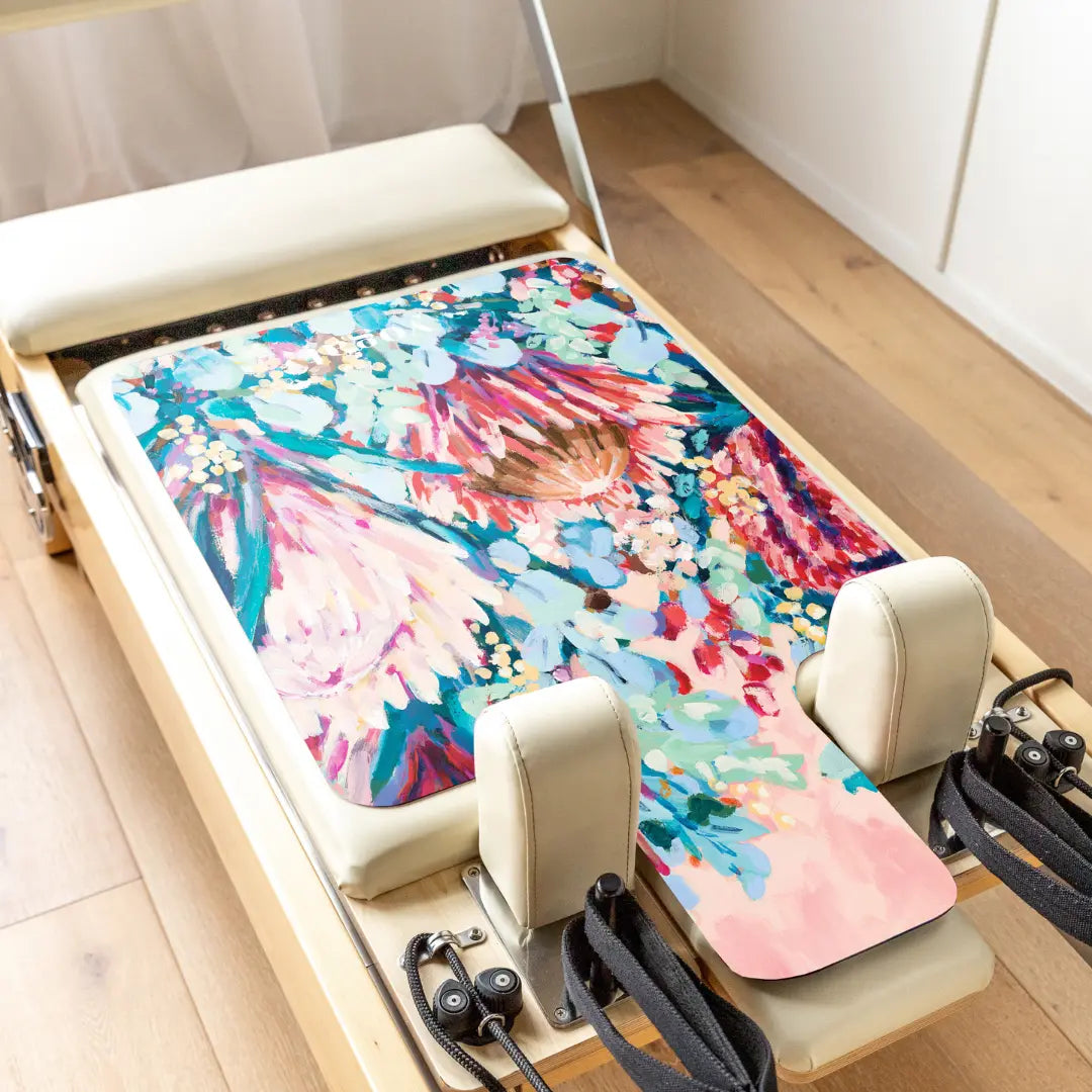 yogat eco-friendly non-slip reformer Pilates mat placed on a studio reformer machine, featuring artistic design and sustainable materials